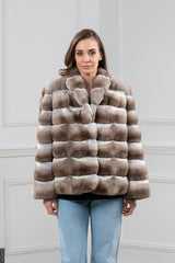 Dark beige chinchilla fur jacket with a V chevron pattern. It has a standing collar, horizontal fur panels, and a straight-cut waist.