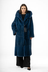 A blue mink fur coat with a hood and horizontal panels. The long, straight-cut coat features visible seams and a black inner lining tag.