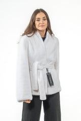 White short mink fur jacket with a high collar, open front, and a matching fur tie belt at the waist. MANZARI tag attached to the belt.