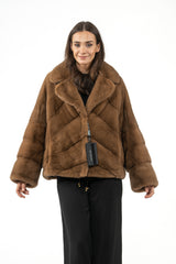 Maple mink short jacket with a wide lapel collar, featuring a V-chevron pattern on the body and horizontal panels on the long sleeves.