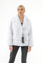 White mink fur short jacket with a wide collar and horizontal pelt construction, featuring a hanging black brand tag on the front.