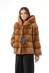 Gold mink fur jacket with a hood, featuring horizontal panels throughout the body and sleeves and a front closure.