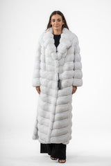 Full-length snow white chinchilla coat with a wide collar and a vertical V-chevron fur pattern. Features long sleeves and hidden front closures.