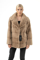 A sand-colored mink fur short jacket with horizontal panel construction and a wide notched collar, viewed from the front.