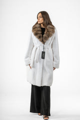 White mink fur jacket with a wide, brown fur collar, a matching tie belt at the waist, and straight sleeves, worn over black trousers.