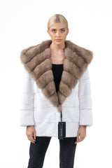 White mink fur jacket with horizontal panels and a large hood featuring light brown bobmarten fur with a V-chevron pattern, viewed from the front.