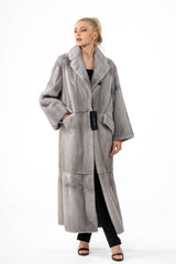 Long sapphire mink fur coat with wide lapels, large side pockets, and a panelled construction featuring horizontal bands on the hem.
