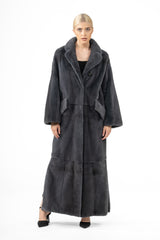 A long grafite mink fur coat featuring a wide notched collar, two angled side pockets, and a horizontal seam at the waist and lower hem.