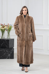 Front view of a long pastel mink coat showing the collar construction, a hidden closure, and patch pockets with directional fur panels.