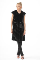 A black mink fur vest featuring a V-chevron pattern, a round collarless neckline, and a knee-length silhouette.