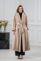 A Palomino mink fur coat featuring a wide shawl collar, turn-back cuffs, and a matching tie belt over an open front, reaching below the knees.