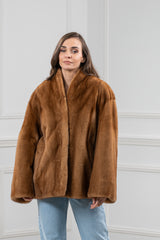Gold mink fur short jacket with a wide standing collar, straight silhouette, and loose, flared sleeves, worn over light wash blue jeans.