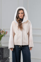 Short pearl mink fur jacket with a hood, featuring horizontal fur pelts, a straight-cut silhouette, and a gold-toned drawstring hem detail.