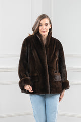 Mahogany mink short jacket with a standing collar, wide sleeves featuring folded cuffs, and two front pockets with horizontal panel detailing.