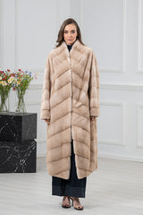 A full-length Palomino mink fur coat featuring a V-chevron pattern on the body and sleeves, with a stand-up collar and a straight silhouette.