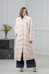 Pearl mink fur coat with a V chevron pattern on the front, stand collar, and straight sleeves. The long coat falls below the knees.