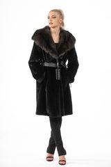A black mink fur jacket featuring a plush, dark brown hood, secured with a leather tie belt at the waist.