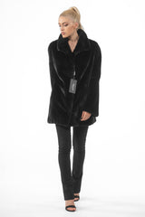 Front view of a black mink fur short jacket with a wide collar, full-length sleeves, and a straight silhouette on a model.