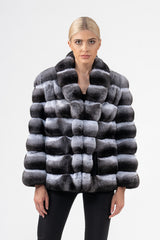 Front view of a chinchilla jacket with horizontal fur panels in alternating grey, white, and black tones, featuring a folded collar.