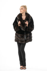 Black mink jacket with a brown fur collar and cuffs, featuring horizontal banding on the lower portion and wide sleeves.