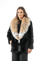 Short black mink fur jacket featuring a large, wide collar in patterned, beige and white fur, worn over a dark outfit with a brand tag.
