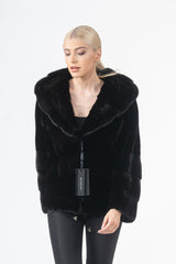 Front view of a Blackglama mink short jacket with a large hood, featuring horizontal pelts and a central closure tag.