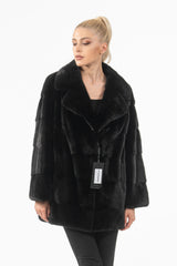 Short black mink fur jacket featuring a wide lapel collar, horizontal panels, and long sleeves on a model in a front-facing pose.