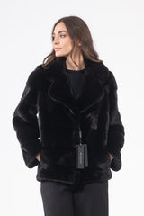 A short black mink jacket with a wide lapel collar and horizontal fur panels, shown from the front with side pockets and a brand tag.