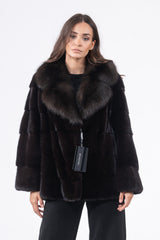 Front view of a black mink fur jacket featuring horizontal panels and a large, wide collar in a darker brown fur texture.