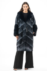 A profondo blue Swakara jacket with a V-chevron pattern, a wide notched collar, and contrasting deep blue fur cuffs. The fit is mid-length.