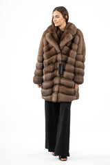 Brown Russian sable jacket with a notched collar and horizontal paneling. The coat features long sleeves and is worn over black trousers.