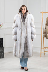 A fawn light fox fur coat featuring a full-length silhouette with a dark-tipped collar and vertical fur pelts on the front and sleeves.