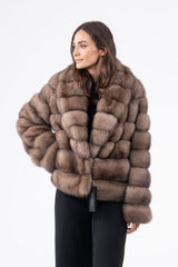 Gun metal Russian sable short jacket featuring a wide collar and horizontal pelt construction, styled with a front closure and black ensemble.