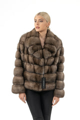 A short, front-facing Russian sable jacket with a horizontal block-panel pattern and a wide collar, styled over black trousers.