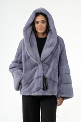 Lilac mink fur short jacket featuring a hood and V chevron pattern on the bodice with horizontal panels on the sleeves.