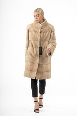 A Palomino mink fur jacket with horizontal fur panels, a high stand collar, long sleeves, and a straight silhouette against a white background.