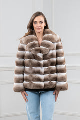 Dark beige chinchilla fur jacket with horizontal banded panels. Features a wide collar, full-length sleeves, and a hip-length boxy fit.