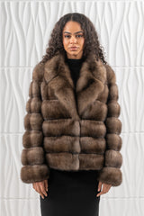 A short Russian sable jacket featuring horizontal fur panels with wide lapels and simple sleeves, worn over a plain black outfit.