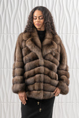 A brown Russian sable short jacket featuring a V chevron pattern, a wide lapel collar, long sleeves, and a sleek, hip-length silhouette.