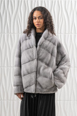 Sapphire mink short jacket featuring a structured collar, loose sleeves, and a multi-directional panel construction with visible side pockets.