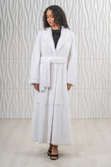 A long, white mink fur coat featuring a wide notched collar and a matching fur tie belt at the waist with a smooth, uniform fur texture.