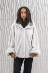 White teddy bear mink short jacket featuring an attached hood and wide cuffs, worn over black trousers with a drawstring hem detail.