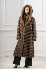 A brown Russian sable coat with an integrated hood. The fur is worked in a V chevron pattern pointing downwards, featuring long sleeves and a midi length.