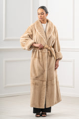 Full-length Palomino mink fur coat featuring a wide shawl collar, voluminous sleeves with folded cuffs, and a matching tan leather waist tie.