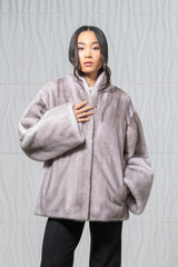Silver blue mink fur short jacket with a stand-up collar, wide sleeves, and a hidden hook-and-eye front closure, set against a white wall.