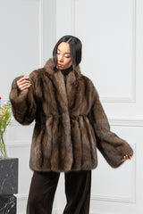 Russian sable short jacket in brown with a high collar, gathered waist construction, and wide sleeves, worn with dark trousers.