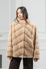 Palomino mink fur short jacket with a V chevron pattern on the front panels, a stand-up collar, and horizontal bands on the sleeves.