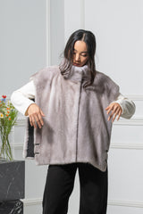 Silver blue mink fur vest with a high collar and open armholes, featuring decorative dark tab details at the hip and dark monogrammed lining.
