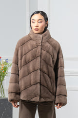 Taupe mink fur short jacket with a front V chevron pattern, stand collar, and straight sleeves in a smooth, velvet-like finish.