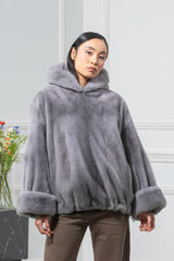 Short sapphire mink fur jacket featuring a hood, wide sleeves with thick cuffs, and a cinched drawstring hemline in a smooth, velvet-like texture.